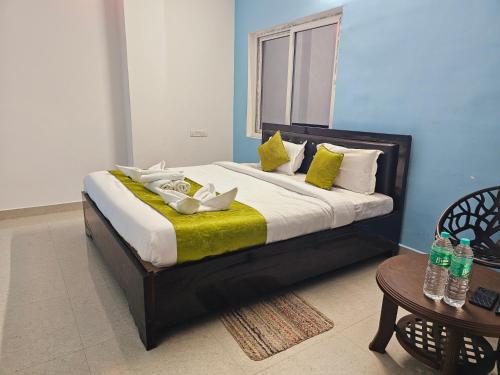 Una cama con almohadas amarillas y blancas y una mesa. en Hotel Sea Rock, en Puri