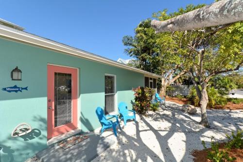 a house with blue chairs in front of it at Minnow 2 Villa in Anna Maria