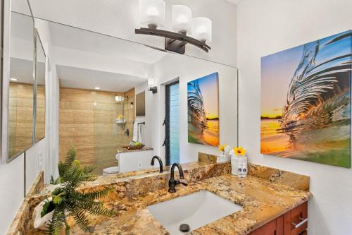 a bathroom with a sink and a large painting on the wall at Kihei Alii Kai A101 in Kihei