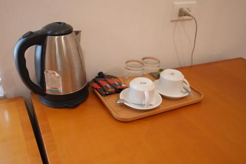- Hervidor de té y 2 tazas en una mesa en Golden Sunshine Villa Hotel and Travel, en Hanói