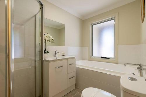 een badkamer met een bad, een toilet en een wastafel bij Peaceful Seabreeze Retreat in Kiama