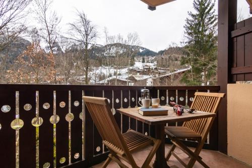 里雾诗Résidence Le Château - D86 - Happy Rentals的阳台上有一张桌子和两把椅子，可以欣赏美景