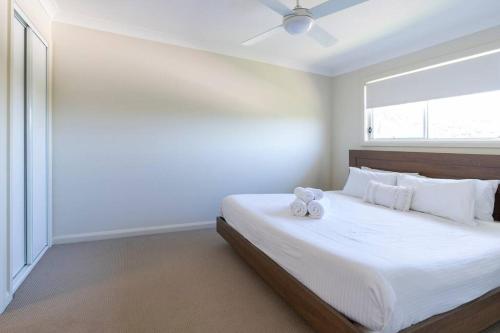 een slaapkamer met een groot bed en 2 handdoeken bij Peaceful Seabreeze Retreat in Kiama