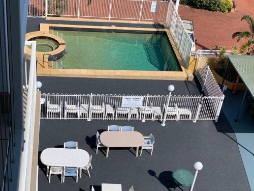 Marina Views Apartment Cullen Bay في Larrakeyah: اطلالة علوية على مسبح به طاولات وكراسي