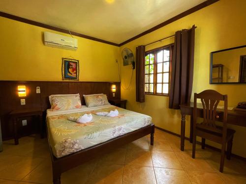 a bedroom with a bed and a desk and a chair at Tipolo Beach Resort in Moalboal