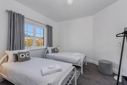 - une chambre avec 2 lits et une fenêtre dans l'établissement Best on Letitia Central spacious stylish sleeps 6, à Hobart