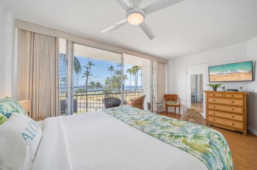 a bedroom with a bed and a view of the ocean at Island Surf 306 in Kihei