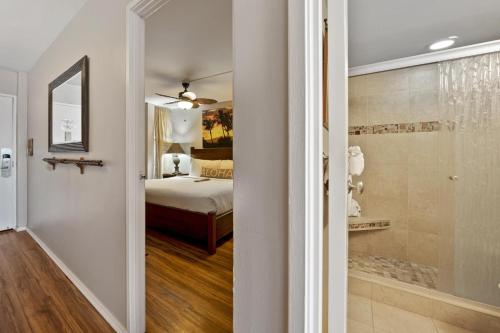 a hallway leading to a bedroom with a bed and a shower at Island Sands 210 in Maalaea