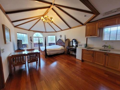 a living room with a bed and a kitchen at Sunset Jeju in Jeju