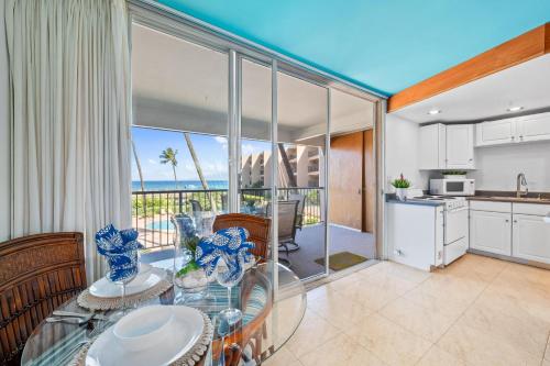 a kitchen and dining room with a view of the ocean at Hale Ono Loa 214 in Kahana