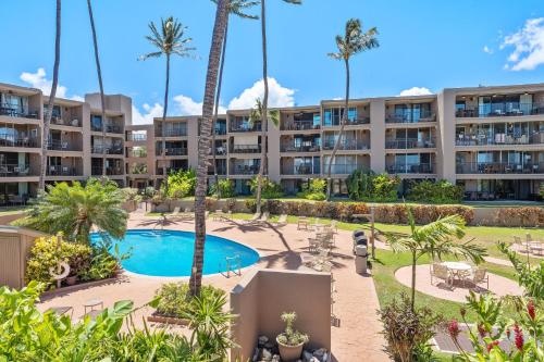 an apartment complex with a pool and palm trees at Hale Ono Loa 214 in Kahana