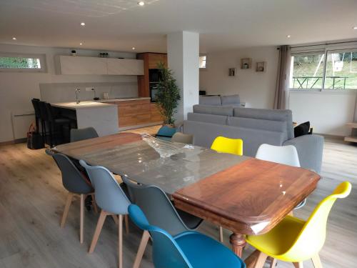 eine Küche und ein Esszimmer mit einem Holztisch und Stühlen in der Unterkunft Gîte des Gônes - Lyon Charme in Feyzin