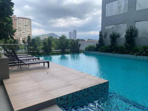 uma piscina com um banco num edifício em 2 Bedroom Cozy Suite with Attached Bathrooms em Kuala Lumpur