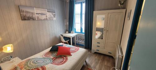 Un pequeño dormitorio con una cama con un libro rojo. en Résidence Fleur des Pins - Gites & Chambres d'Hôtes en Saint-Georges-dʼOléron