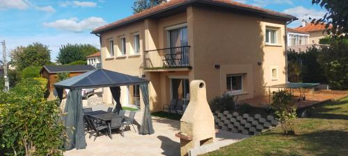 uma casa com uma mesa e um gazebo em Gîte des Gônes - Lyon Charme em Feyzin