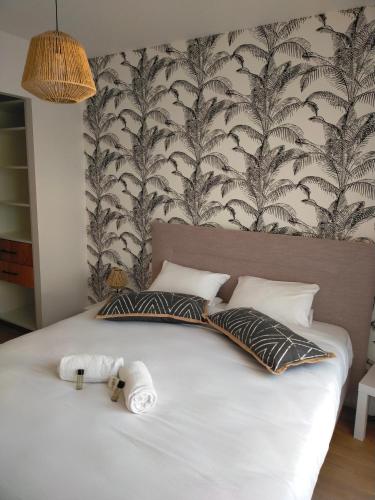 a bedroom with a bed with two towels on it at Gîte climatisé à 15 min de Lyon avec jardin privé in Feyzin