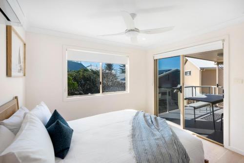 a bedroom with a bed and a large window at Bombora in Lennox Head