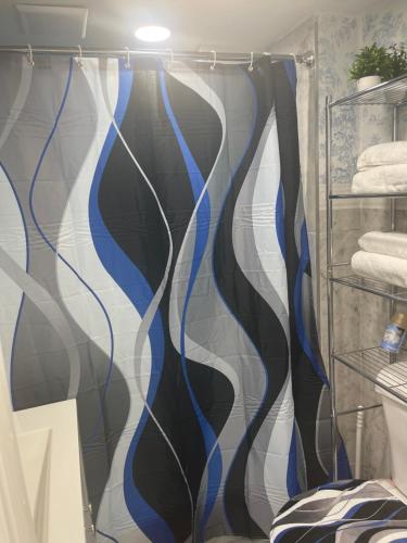 cortina de ducha con rayas azules y blancas en el baño en A unique beautiful home en Elmont