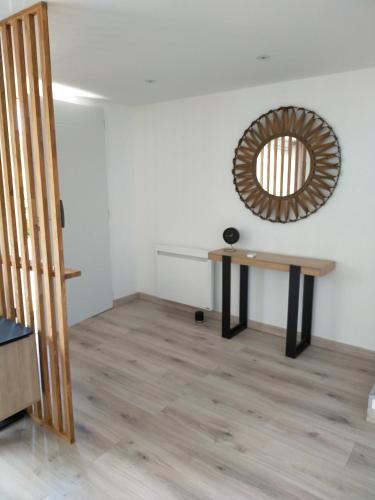 a room with a table and a mirror on the wall at Gîte climatisé à 15 min de Lyon avec jardin privé in Feyzin