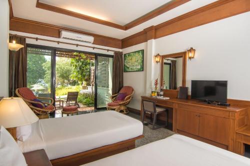 um quarto de hotel com uma cama, uma secretária e uma televisão em Sea View Koh Chang em Ko Chang