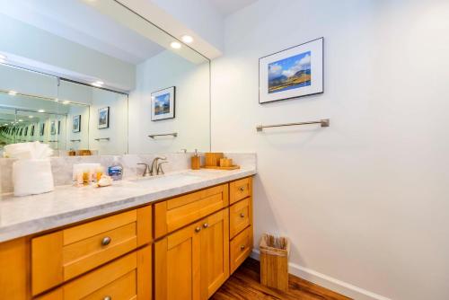 a bathroom with a sink and a large mirror at Eldorado K102 in Kahana