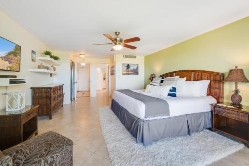 a bedroom with a large bed and a ceiling fan at Eldorado K103 in Kahana