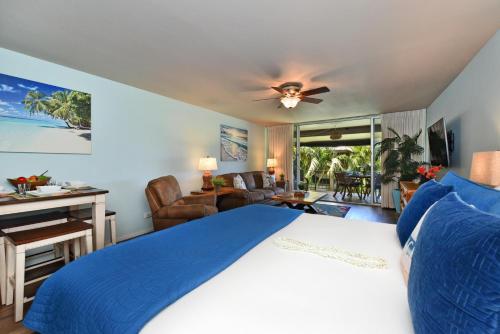 ein Schlafzimmer mit einem blauen Bett und ein Wohnzimmer in der Unterkunft Eldorado J218 in Kahana