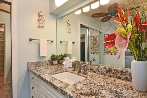 a bathroom with a sink and a large mirror at Eldorado J218 in Kahana