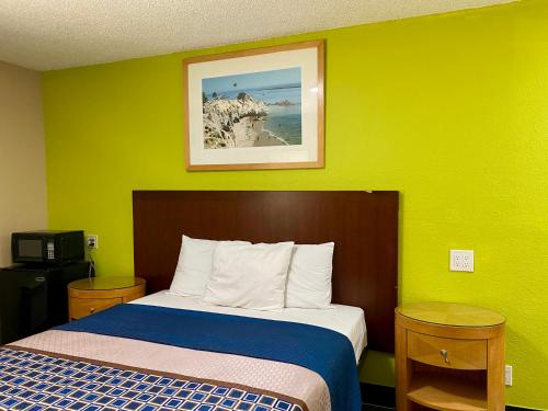 un letto in una camera con parete verde di 4 Star Motel a Los Angeles