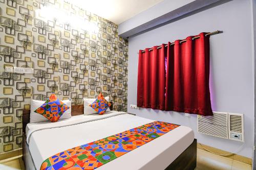 a bedroom with two beds and a red curtain at FabExpress Westin Palaza in kolkata