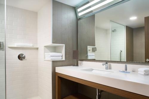 a bathroom with a sink and a mirror at Courtyard by Marriott Merida Downtown in Mérida