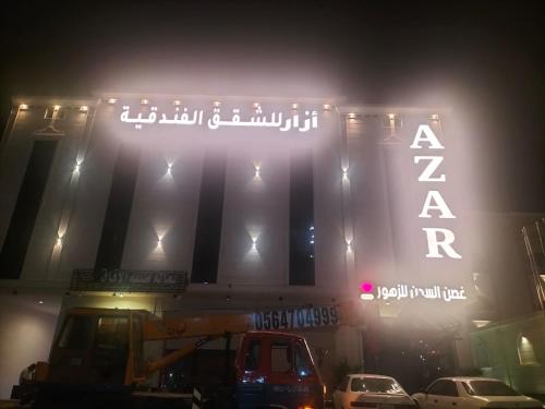 a sign for a theatre at night with cars parked in front at أزار للشقق الفندقية in Abyār ‘Alī