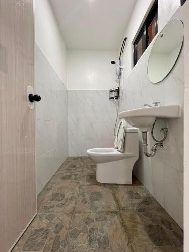 a bathroom with a toilet and a sink at Ana's Bungalow in Siquijor