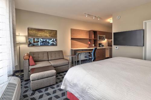 a hotel room with a bed and a couch and a kitchen at TownePlace Suites by Marriott Albuquerque Old Town in Albuquerque