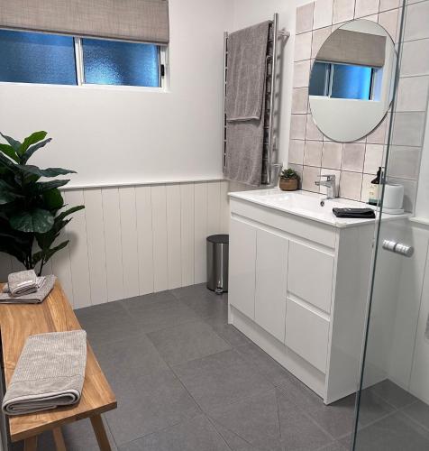 a white bathroom with a sink and a mirror at Sunrise Beach Holiday Apartment in Sunrise Beach
