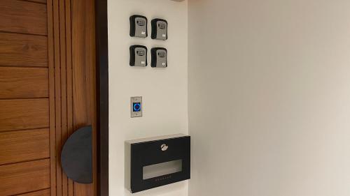 a wall with three cell phones on a wall next to a door at The Tangerine Guesthouse in Bangkok