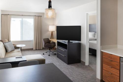 a hotel room with a television and a living room at Residence Inn by Marriott Fairfield Napa in Fairfield