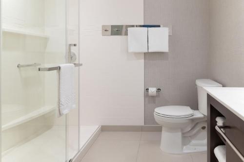 a white bathroom with a toilet and a shower at Residence Inn by Marriott Fairfield Napa in Fairfield