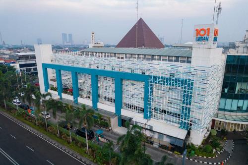 1O1 URBAN Jakarta Kelapa Gading في جاكرتا: مبنى كبير ذو سقف ازرق على شارع المدينة