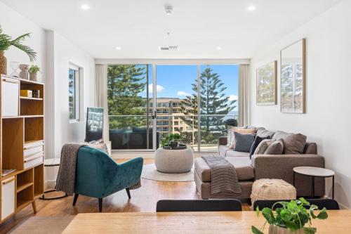 a living room with a couch and chairs and a large window at Belle Escapes - Aquarius on Colley Terrace 2 bed-2bath with sea views in Glenelg