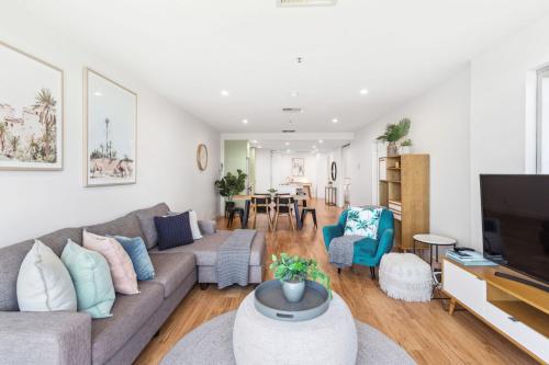 a living room with a couch and a tv at Belle Escapes - Aquarius on Colley Terrace 2 bed-2bath with sea views in Glenelg