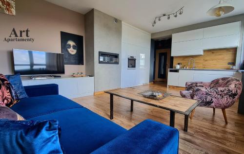 卡利什的住宿－Art Apartamenty Złota，客厅配有蓝色的沙发和桌子