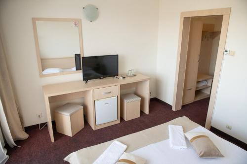 a hotel room with a bed and a mirror at Hotel Panoramic in Râmnicu Vâlcea
