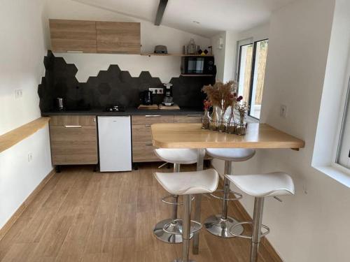 a kitchen with a counter and stools in a room at Micro maison Lyon 8/ Parking / Terrain de pétanque in Bron