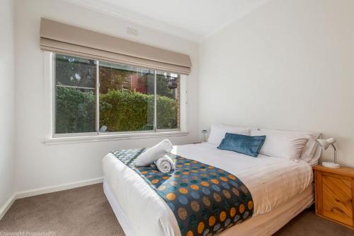 ein Schlafzimmer mit einem Bett und einem Fenster in der Unterkunft City Lights Spacious walk to restaurant strip in New Town