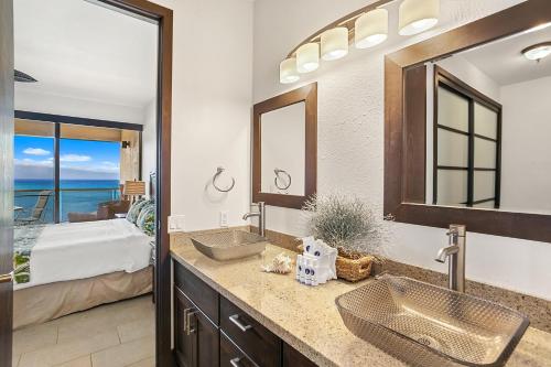 a bathroom with two sinks and a bedroom with a bed at Sands of Kahana 354 in Kahana
