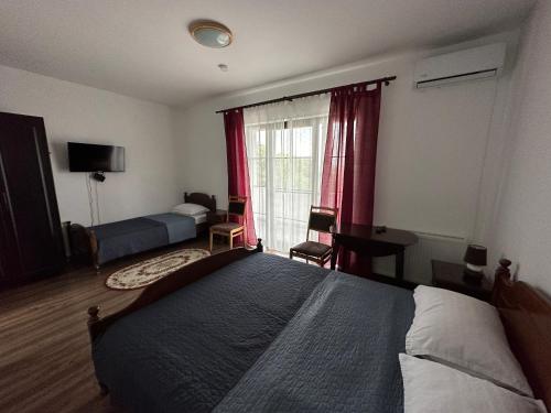a bedroom with a large bed and a window at Pensiunea Emelys, Iasi in Iaşi
