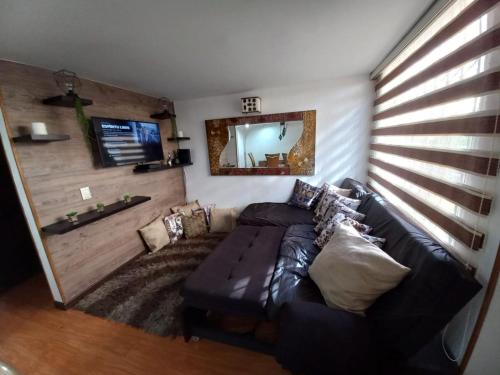 - un salon avec un canapé en cuir et un miroir dans l'établissement Casa amoblada en Colina Campestre, à Bogotá