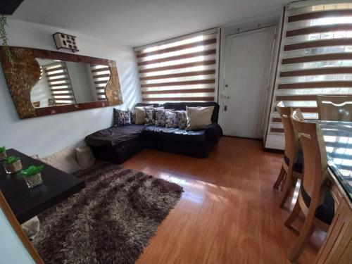 uma sala de estar com um sofá e uma mesa em Casa amoblada en Colina Campestre em Bogotá