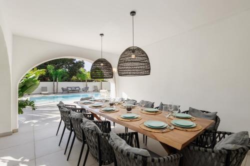 マルベーリャにある6 bedroom villa, with heated pool and sea views, next to the beach of Costabellaのダイニングルーム(テーブル、椅子付)、プール